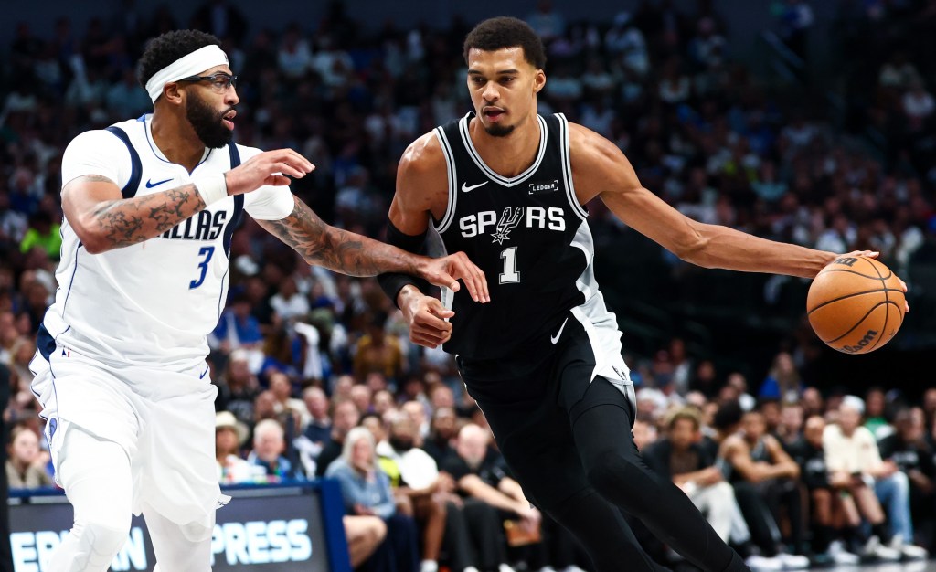 Victor Wembanyama drives on Anthony Davis during the Spurs' opening-night road win over the Mavericks.
