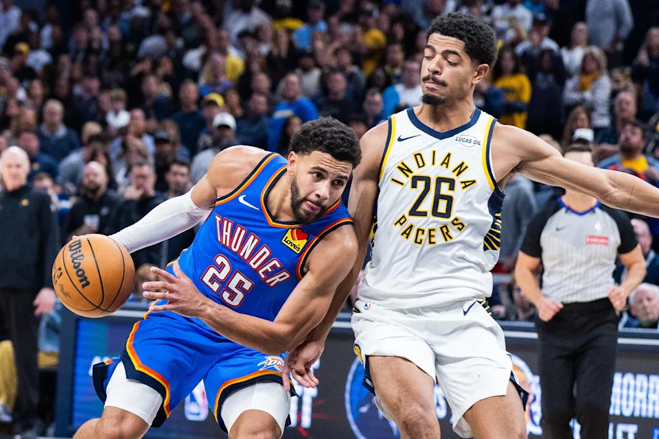 Oct 23, 2025; Indianapolis, Indiana, USA; Oklahoma City Thunder guard Ajay Mitchell (25) dribbles the ball while Indiana Pacers guard Ben Sheppard (26) defends in the second half at Gainbridge Fieldhouse. Mandatory Credit: Trevor Ruszkowski-Imagn Images
