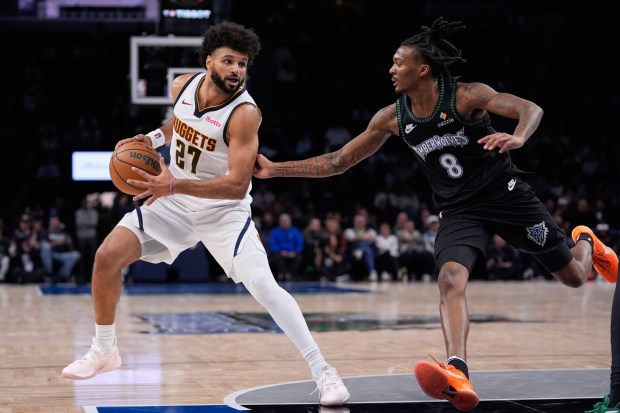 Denver Nuggets guard Jamal Murray (27) works toward the basket as Minnesota Timberwolves guard Bones Hyland (8) defends during the second half of an NBA basketball game, Monday, Oct. 27, 2025, in Minneapolis. (AP Photo/Abbie Parr)