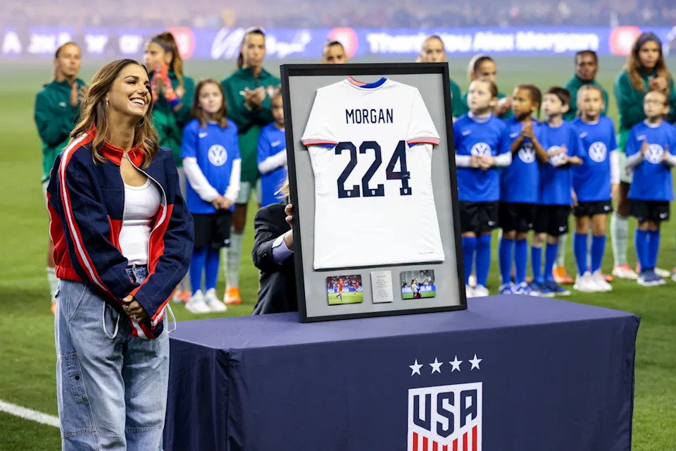 Morgan stands next to a jersey representing her 224 appearances with the USWNT. (Heather Barry/Getty Images)