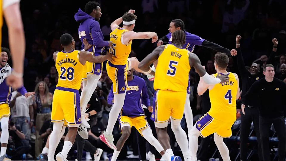 Austin Reaves celebrates with his Lakers teammates after sinking a game-winning shot at the buzzer to beat the Timberwolves.