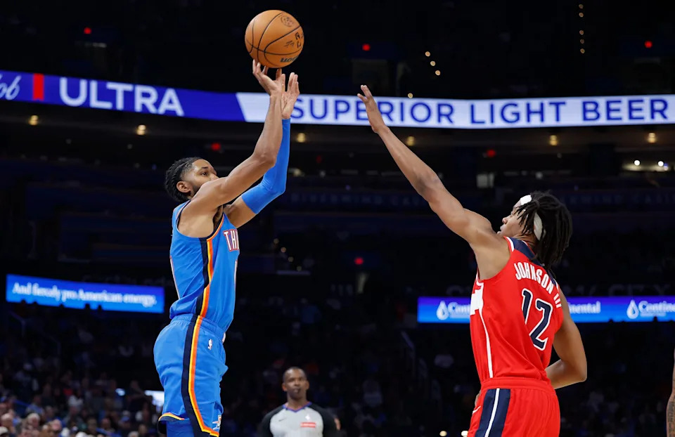 Oct 30, 2025; Oklahoma City, Oklahoma, USA; Oklahoma City Thunder guard Isaiah Joe (11) shoots a three point basket over Washington Wizards guard Tre Johnson (12) during the second half at Paycom Center. Mandatory Credit: Alonzo Adams-Imagn Images