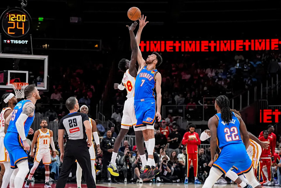 Oct 25, 2025; Atlanta, Georgia, USA; Atlanta Hawks forward Mouhamed Gueye (18) and Oklahoma City Thunder center Chet Holmgren (7) reach for the opening tip off during the first half at State Farm Arena. Mandatory Credit: Dale Zanine-Imagn Images