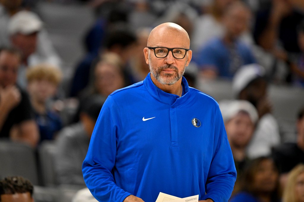 A male coach in a blue Dallas Mavericks jacket with a Nike swoosh.
