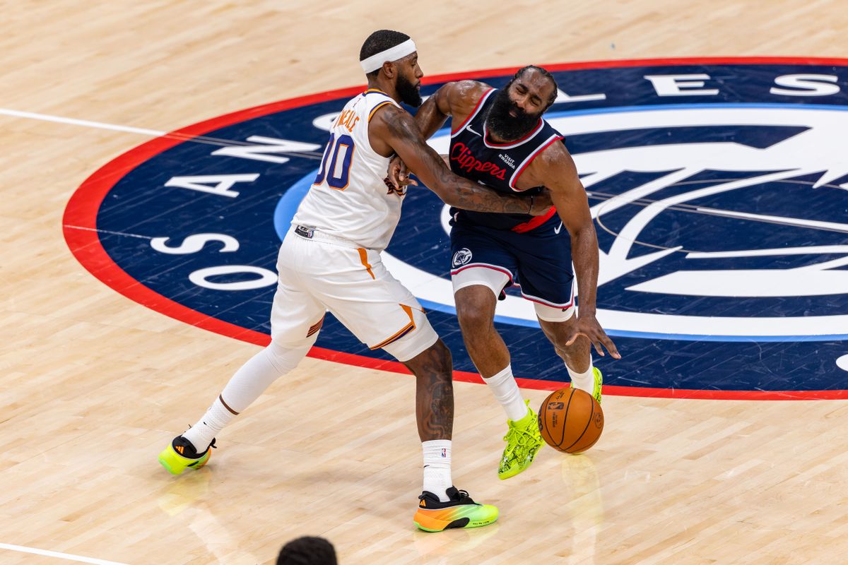 Forward Royce O'Neale #00 of the Phoenix Suns fouls guard James Harden #1 of the LA Clippers during an NBA game at the Intuit Dome on October 24, 2025 in Inglewood California.