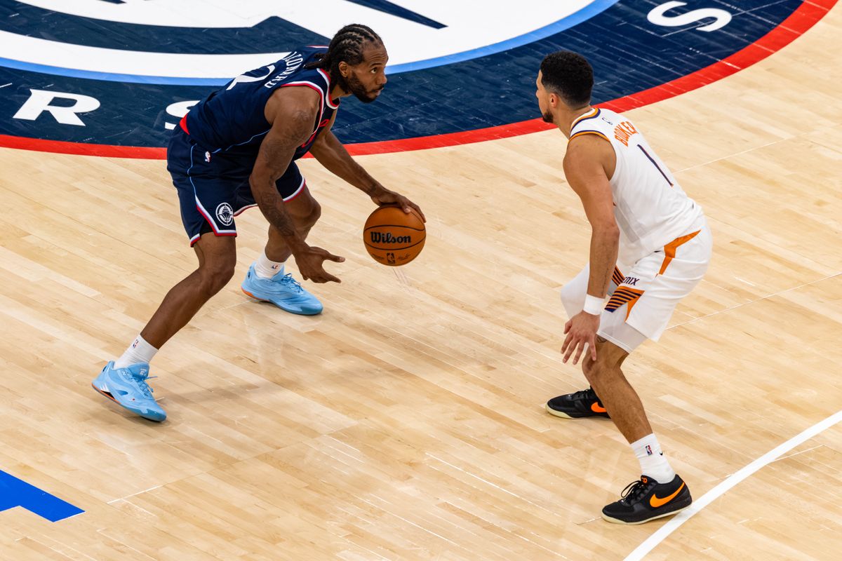 Forward Kawhi Leonard #2 of the LA Clippers handles the ball against guard Devin Booker #1 of the Phoenix Suns during an NBA game at the Intuit Dome on October 24, 2025 in Inglewood California.