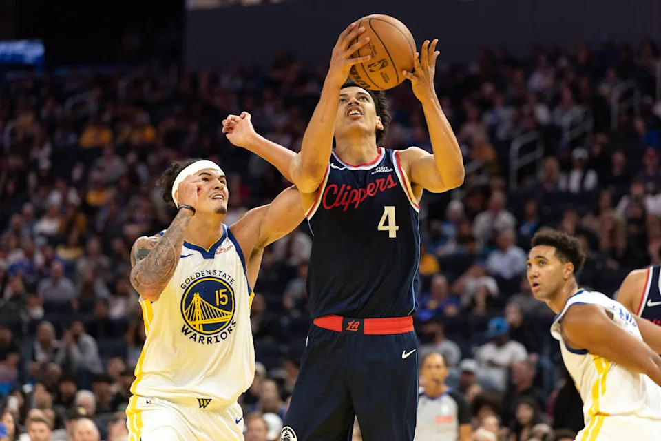 Oct 17, 2025; San Francisco, California, USA; Los Angeles Clippers guard Kobe Sanders (4) shoots ahead of Golden State Warriors forward Gui Santos (15) during the fourth quarter at Chase Center.