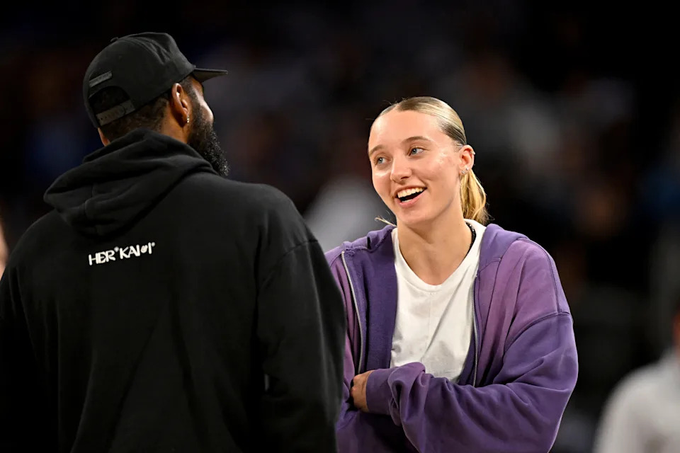 Oct 6, 2025; Fort Worth, Texas, USA; Dallas Mavericks guard Kyrie Irving (left) talks with Dallas Wings guard Paige Bueckers (right) during the second half of the game between the Mavericks and the Oklahoma City Thunder at Dickie's Arena. Mandatory Credit: Jerome Miron-Imagn Images