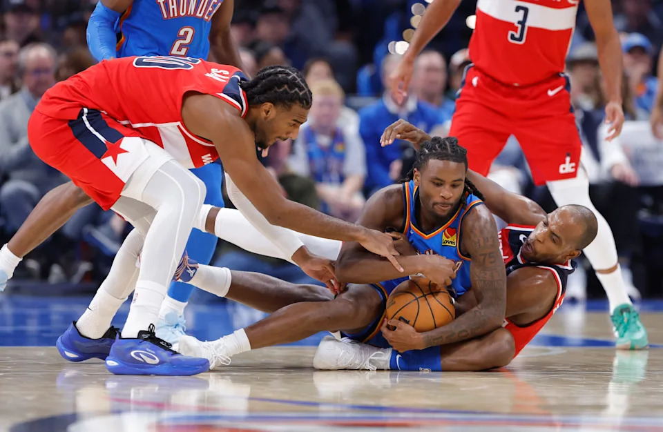 Oct 30, 2025; Oklahoma City, Oklahoma, USA; Oklahoma City Thunder guard Cason Wallace (22) and Washington Wizards forward Khris Middleton (22) fight for a loose ball during the second quarter at Paycom Center. Mandatory Credit: Alonzo Adams-Imagn Images