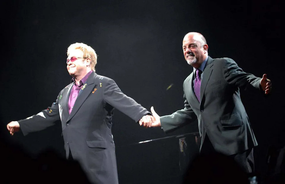 March 7, 2009: Piano men Elton John (left) and Billy Joel greet the audience for the start of their “Face To Face” concert at what was then known as Time Warner Cable Arena.