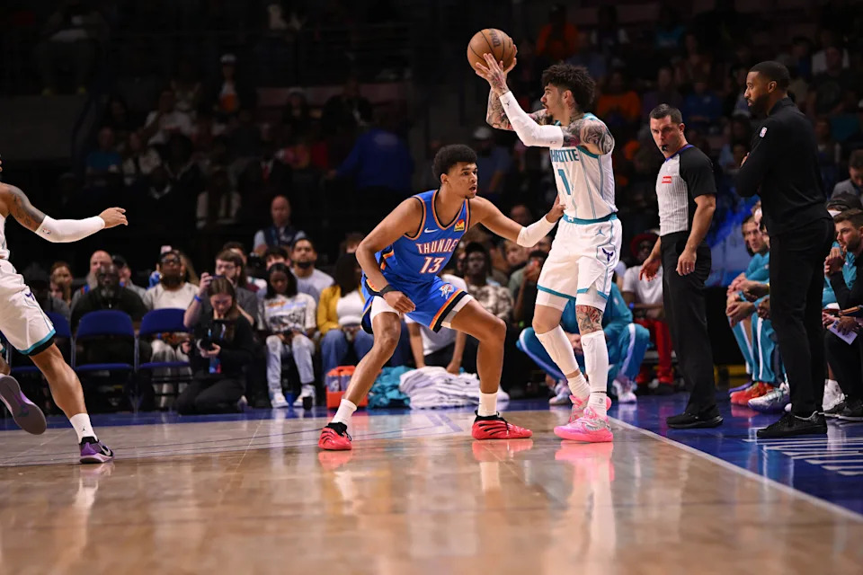 Oct 5, 2025; North Charleston, South Carolina, USA; Charlotte Hornets guard LaMelo Ball (1) passes from the key against Oklahoma City Thunder forward Ousmane Dieng (13) in the first quarter at North Charleston Coliseum. Mandatory Credit: Arthur Ellis-Imagn Images