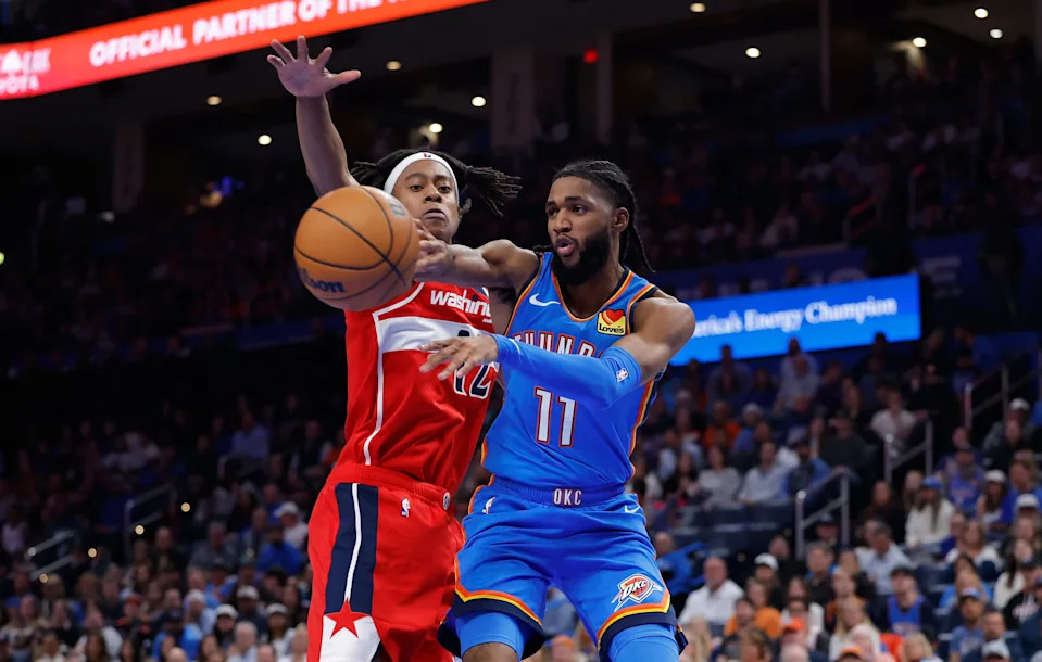 Oct 30, 2025; Oklahoma City, Oklahoma, USA; Oklahoma City Thunder guard Isaiah Joe (11) passes around Washington Wizards guard Tre Johnson (12) during the second half at Paycom Center. Mandatory Credit: Alonzo Adams-Imagn Images
