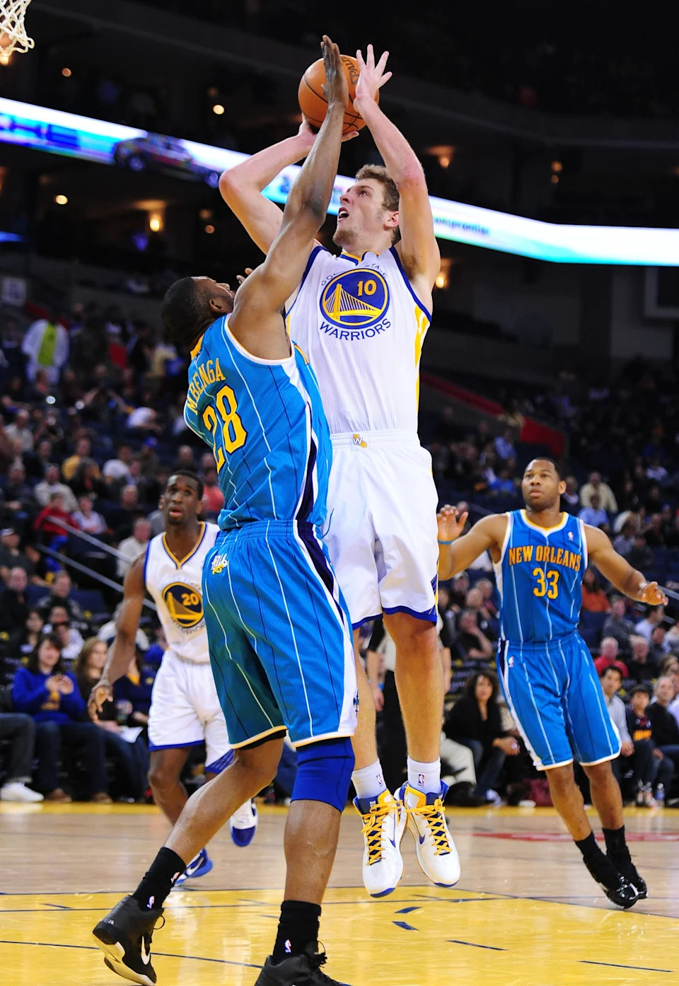 January 26, 2011; Oakland, CA, USA; Golden State Warriors center David Lee (10) shoots the ball over New Orleans Hornets center D.J. Mbenga (28) during the fourth quarter at ORACLE Arena. The Hornets defeated the Warriors 112-103. Mandatory Credit: Kyle Terada-USA TODAY Sports