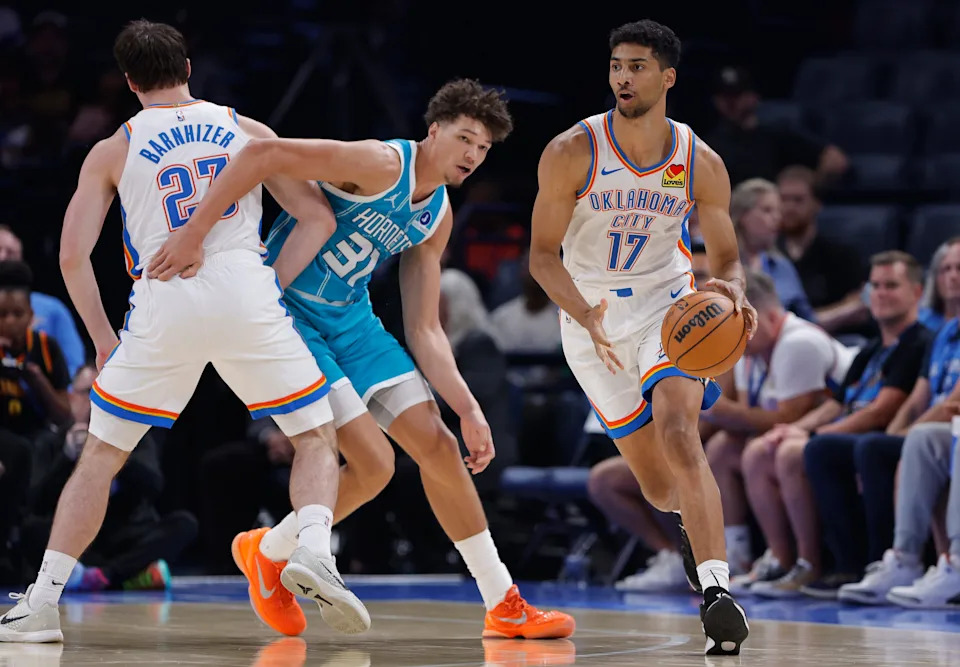Oct 9, 2025; Oklahoma City, Oklahoma, USA; Oklahoma City Thunder forward Malevy Leons (17) moves the ball around Charlotte Hornets forward Tidjane Salaün (31) during the second half of a game between the Charlotte Hornets and the Oklahoma City Thunder at Paycom Center. Mandatory Credit: Alonzo Adams-Imagn Images