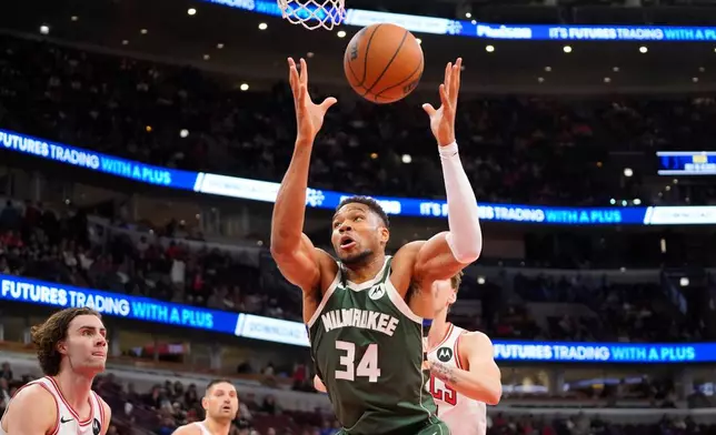 Milwaukee Bucks forward Giannis Antetokounmpo (34) grabs a rebound against the Chicago Bulls during the first half of a preseason NBA basketball game Sunday, Oct. 12, 2025, in Chicago. (AP Photo/David Banks)