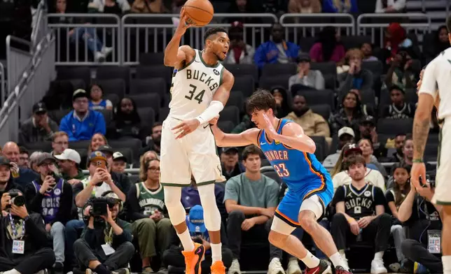 Milwaukee Bucks forward Giannis Antetokounmpo (34) passes the ball against Oklahoma City Thunder guard Brooks Barnhizer (23) during the second half of a preseason NBA basketball game Tuesday, Oct. 14, 2025, in Milwaukee. (AP Photo/Kayla Wolf)