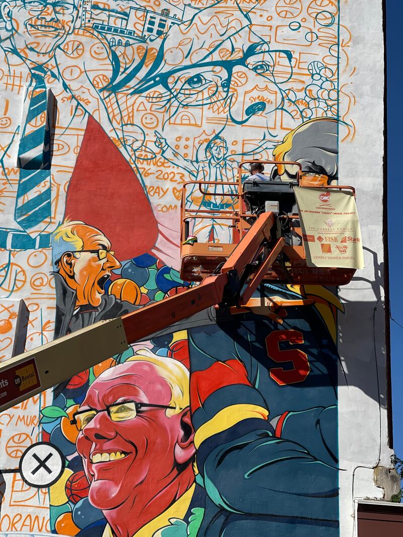 Chris B. Murray paints a mural of Jim Boeheim, longtime coach Syracuse University basketball team, in downtown Syracuse.