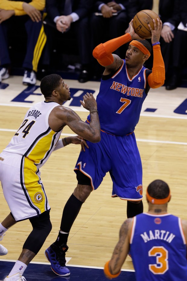 New York Knicks forward Carmelo Anthony, top, shoots over Indiana Pacers forward Paul George during the third quarter of Game 6 of the Eastern Conference semifinal NBA basketball playoff series in Indianapolis, Saturday, May 18, 2013. (AP Photo/Michael Conroy)