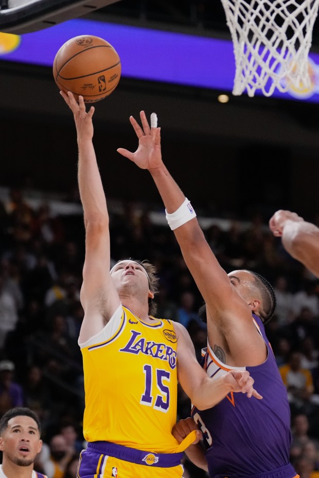 Lakers guard Austin Reaves, left, shoots as Phoenix Suns forward...
