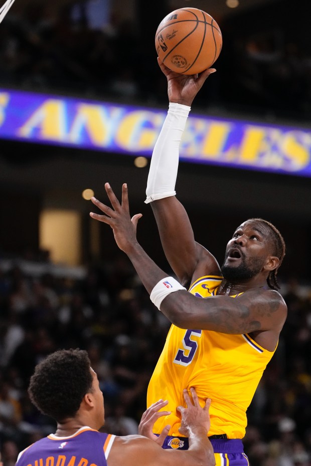 Lakers center Deandre Ayton, right, shoots as Phoenix Suns center...