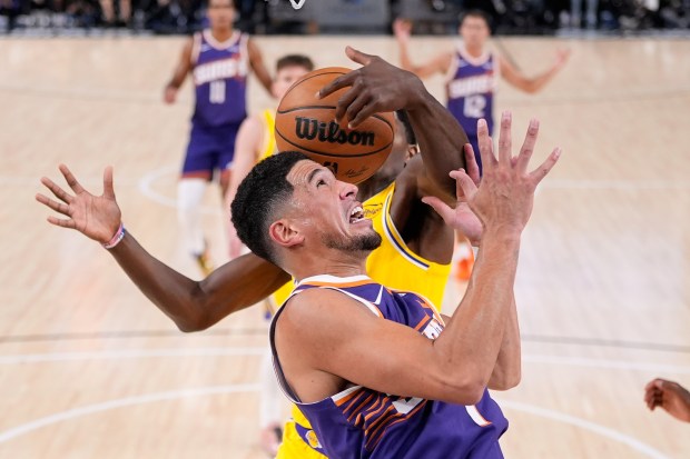 The Lakers’ Nate Williams, back, grabs a rebound away from...