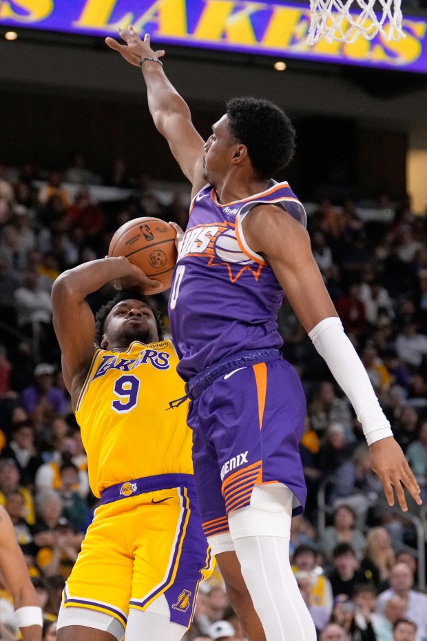 Lakers guard Bronny James, left, shoots as Phoenix Suns forward...