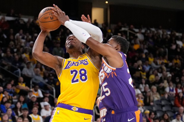 Lakers forward Rui Hachimura, left, shoots as Phoenix Suns guard...