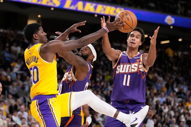 Lakers center Kylor Kelley, left, goes after a rebound along...
