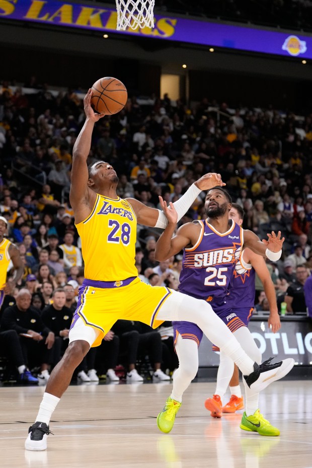 Lakers forward Rui Hachimura, left, shoots as Phoenix Suns guard...