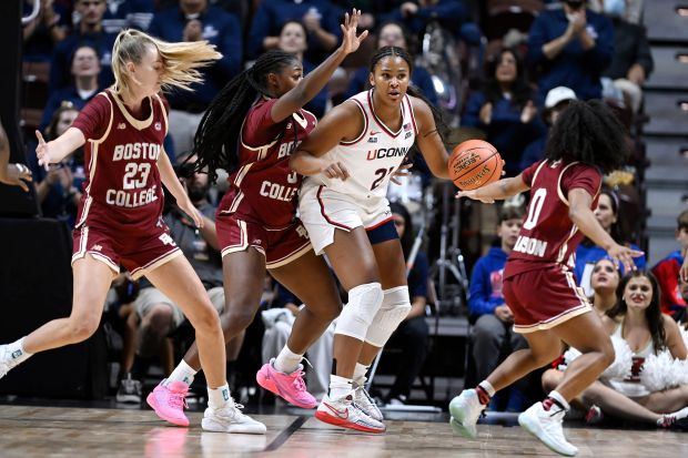 UConn forward Sarah Strong, center, is guarded by Boston College forward Kayla Rolph, left, Boston College guard Ava McGee and Boston College guard Athena Tomlinson, right, in the first half of an exhibition NCAA college basketball game, Monday, Oct. 13, 2025, in Uncasville, Conn. (AP Photo/Jessica Hill)
