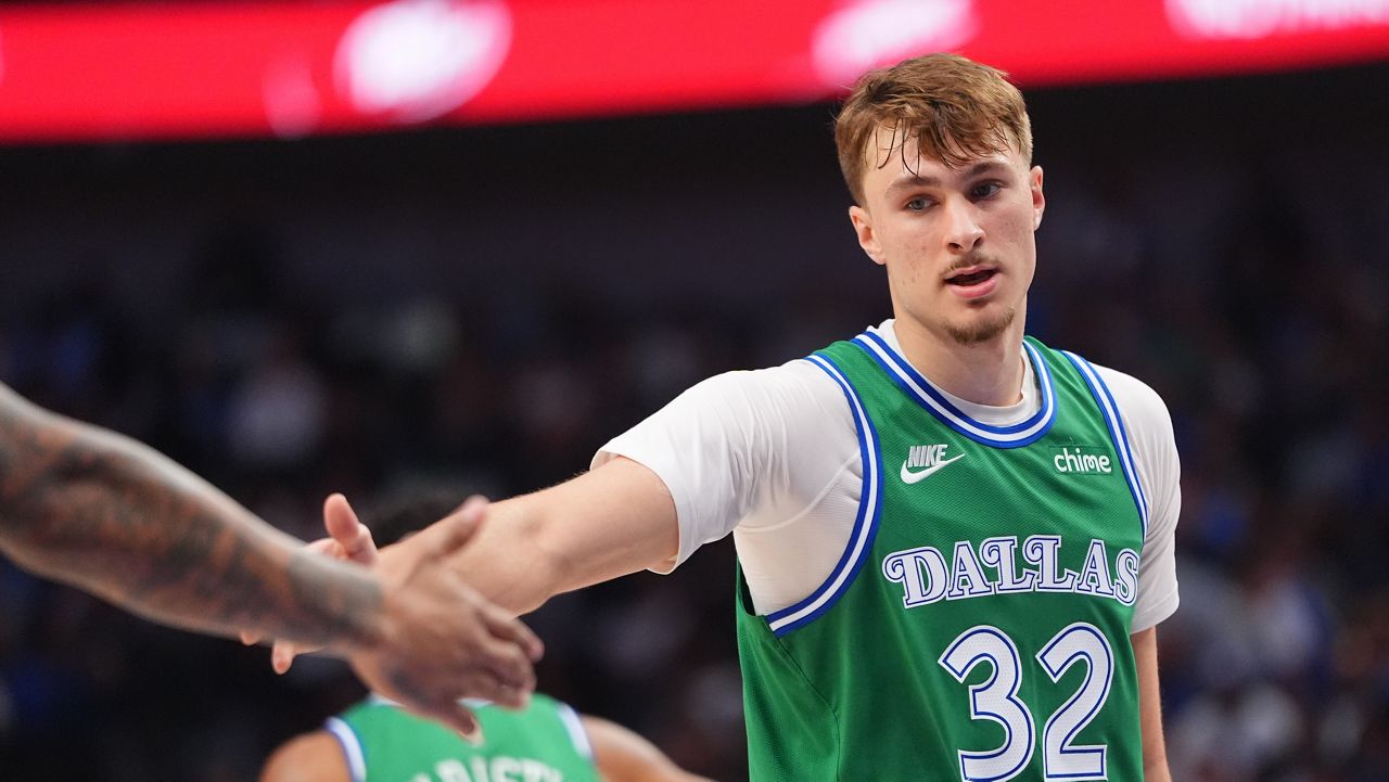 Dallas Mavericks forward Cooper Flagg (32) gets a congratulations from a teammate during the first half of an NBA basketball game against the Toronto Raptors in Dallas, Sunday, Oct. 26, 2025. (AP Photo/LM Otero)