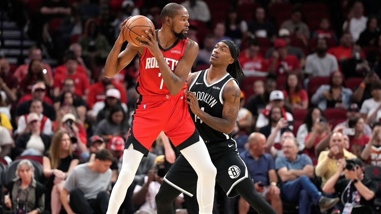 Houston Rockets forward Kevin Durant (7) controls the ball against Brooklyn Nets guard Terance Mann, right, during the first half of an NBA basketball game, Monday, Oct. 27, 2025, in Houston. (AP Photo/Karen Warren)