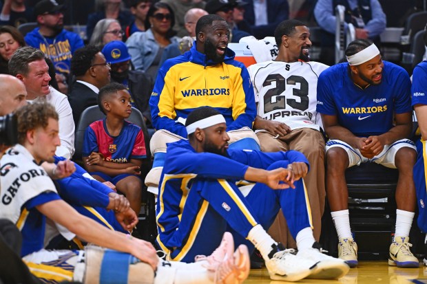 Draymond Jamal Green Jr. sits with his father Golden State Warriors' Draymond Green (23) while playing the Los Angeles Lakers in the second quarter of their preseason NBA game at Chase Center in San Francisco, Calif., on Sunday, Oct. 5, 2025. (Jose Carlos Fajardo/Bay Area News Group)