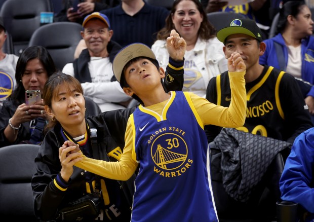Golden State Warriors fans Raito Sato, 9, of Santa Clara,...