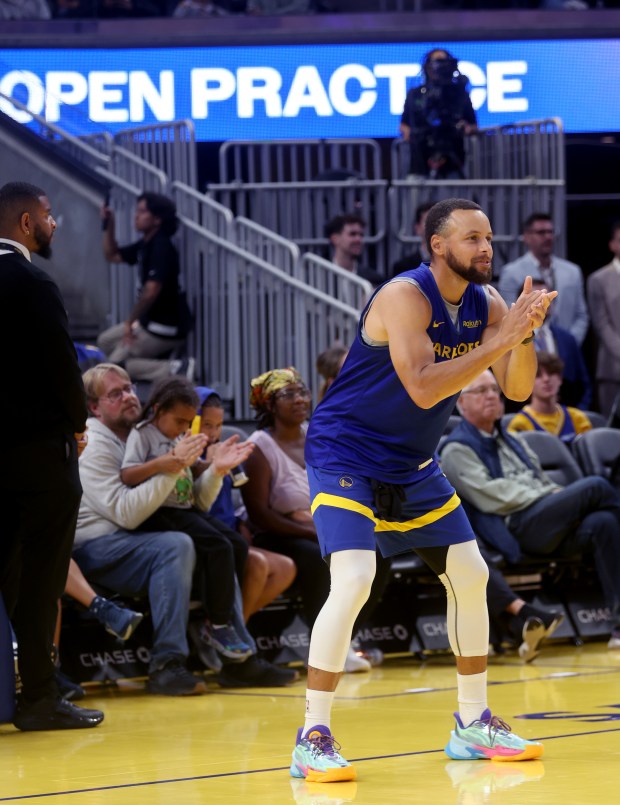 Golden State Warriors' Stephen Curry #30 watches as teammates attempt...