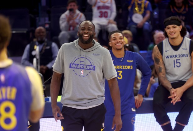 Golden State Warriors' Draymond Green #23 watches rookie teammate LJ...