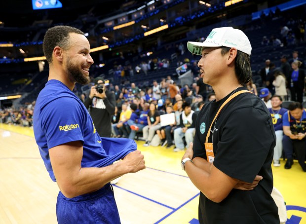 Golden State Warriors' Stephen Curry #30 greets Australian professional golfer...