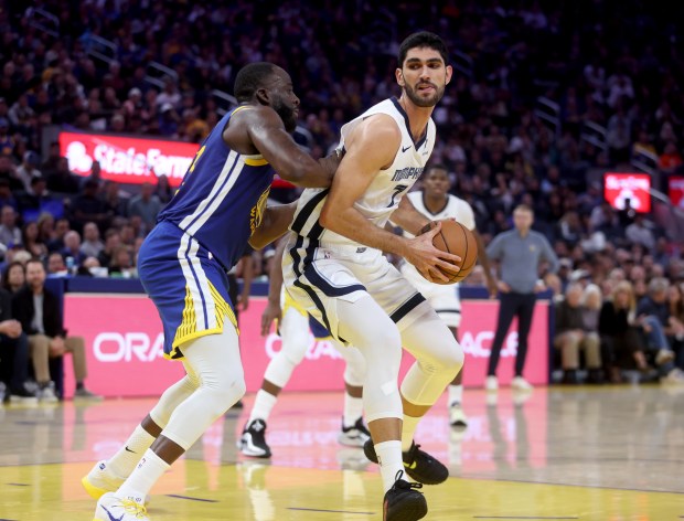 Golden State Warriors' Draymond Green #23 guards Memphis Grizzlies' Santi...