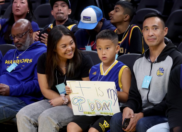 Jordan 9, center, with his parents Kat and T.J. Verceles,...