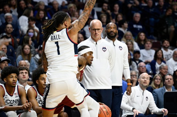 Under the watchful eyes of UConn coach Dan Hurley, Huskies guard Solo Ball turns up the defensive pressure on Boston College's Fred Payne during the first half of Monday's exhibition game. (AP Photo/Jessica Hill)