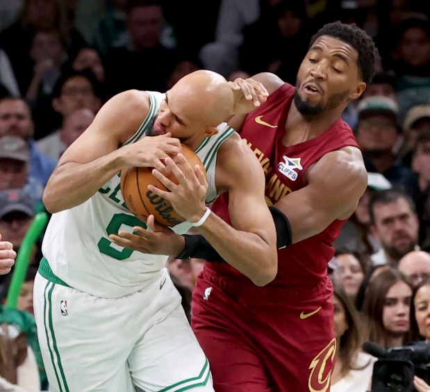 Cleveland Cavaliers guard Donovan Mitchell, right, attempts to wrestle the ball from Boston Celtics guard Derrick White during the second half. (Mark Stockwell/Boston Herald)