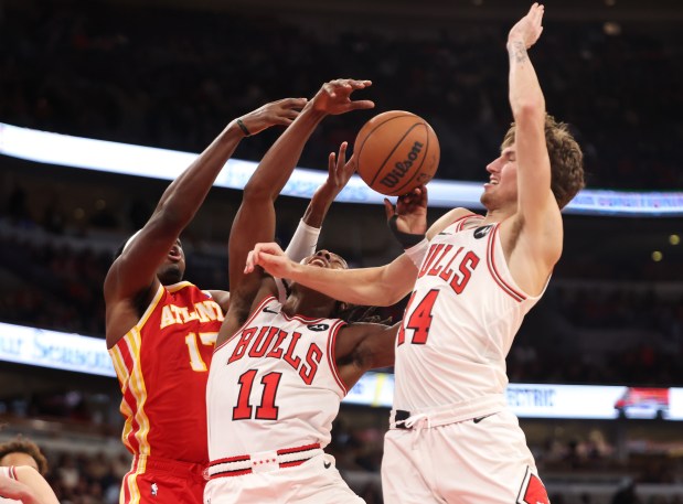 From left: Atlanta Hawks' Onyeka Okongwu (17), Chicago Bulls guard Ayo Dosunmu (11) and Chicago Bulls forward Matas Buzelis (14) go for a rebound in the fourth quarter during a game, Monday, Oct. 27, 2025, at the United Center in Chicago. (Dominic Di Palermo/Chicago Tribune)