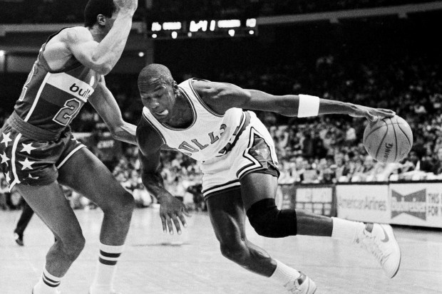 Chicago Bulls' Michael Jordan drives past Washington Bullets' Dudley Bradley during NBA action at Chicago Stadium in Chicago, on Oct. 26, 1984. (Fred Jewell/AP)