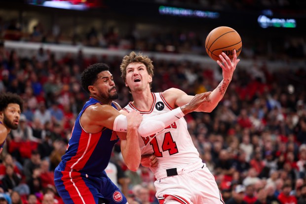 Detroit Pistons forward Tobias Harris (12) fouls Chicago Bulls forward Matas Buzelis (14) during the first quarter of the home opener at the United Center Wednesday Oct. 22, 2025 in Chicago. (Armando L. Sanchez/Chicago Tribune)
