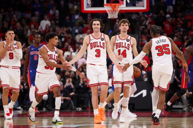 Chicago Bulls guard Josh Giddey (3) high-fives players after making two free throw to make it, 114-111, with less than 15 seconds left in the game during the fourth quarter of the home opener against the Detroit Pistons at the United Center Wednesday Oct. 22, 2025 in Chicago. (Armando L. Sanchez/Chicago Tribune)