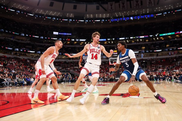 Chicago Bulls center Nikola Vucevic (9) and Chicago Bulls forward Matas Buzelis (14) guard Minnesota Timberwolves forward Jaden McDaniels (3) during the first quarter at the United Center Thursday Oct. 16, 2025, in Chicago. (Armando L. Sanchez/Chicago Tribune)