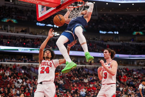 Minnesota Timberwolves guard Donte DiVincenzo (0) dunks the ball over Chicago Bulls forward Noa Essengue (24) and Chicago Bulls guard Josh Giddey (3) during the second quarter at the United Center Thursday Oct. 16, 2025, in Chicago. (Armando L. Sanchez/Chicago Tribune)