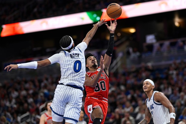 Bulls guard Tre Jones (30) goes up for a shot between Magic guard Anthony Black (0) and forward Paolo Banchero during the first half Saturday, Oct. 25, 2025, in Orlando, Fla. (Phelan M. Ebenhack/AP)