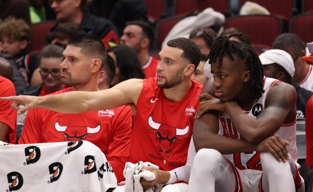 Chicago Bulls guard Zach LaVine (8), center, talks to fellow guard Ayo Dosunmu (12) on the bench in the second quarter against the Denver Nuggets at United Center Friday, Oct. 7, 2022, in Chicago. (John J. Kim/Chicago Tribune)