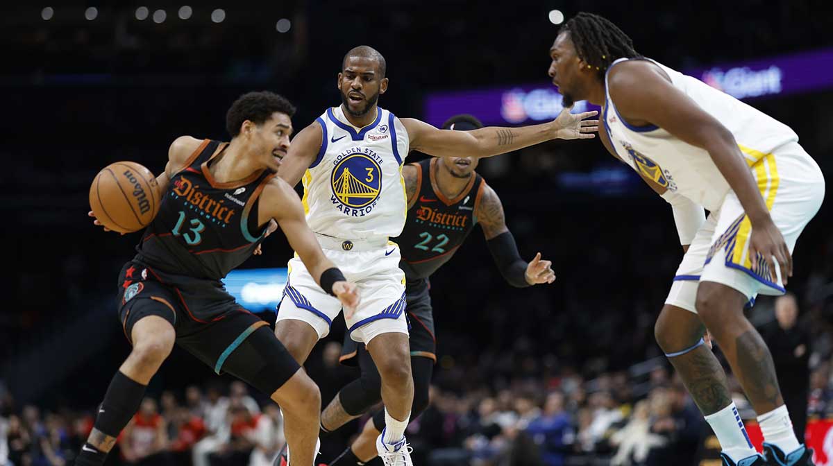 Washington Wizards guard Jordan Poole (13) drives to the basket as Golden State Warriors guard Chris Paul (3) defends in the first half at Capital One Arena.